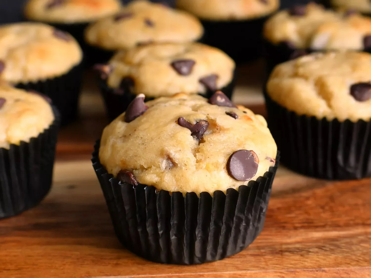 Freshly baked banana chocolate chip muffins on a kitchen counter.