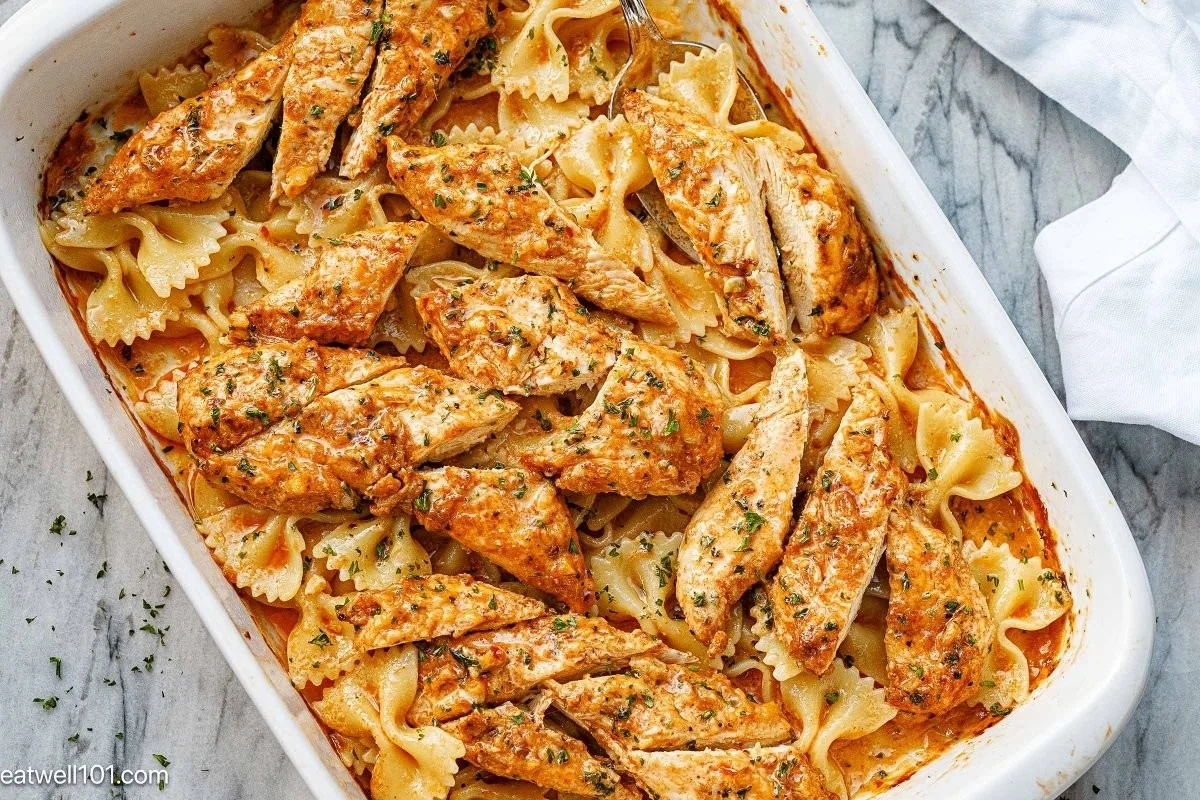 A creamy plate of Bang Bang Chicken Pasta garnished with herbs and spices.