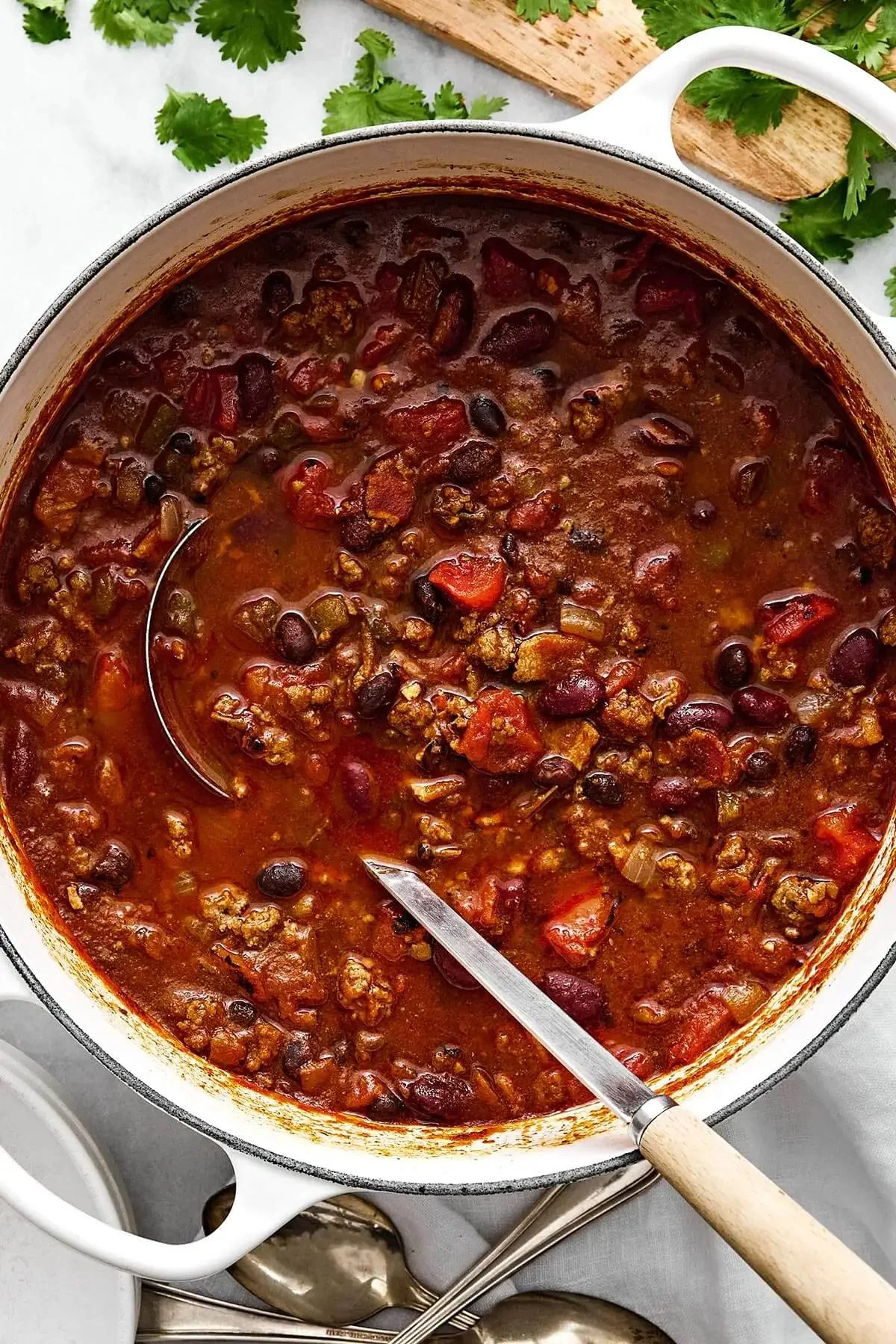 Hearty bowl of the best ever chili recipe topped with cheese and herbs