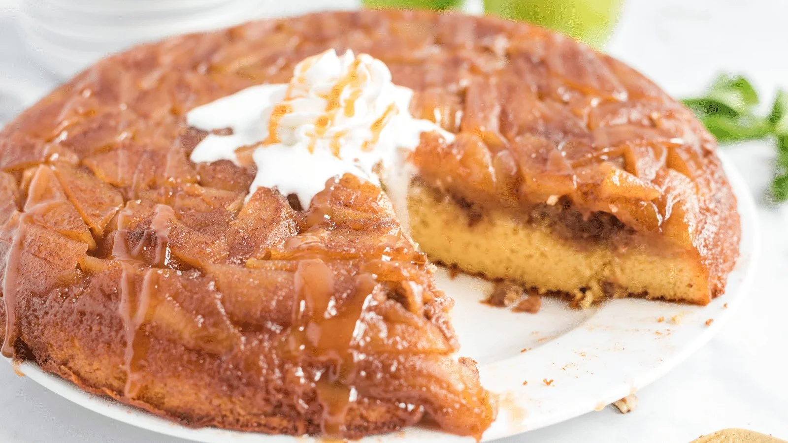 Caramel apple upside down cake topped with caramel sauce and apple slices