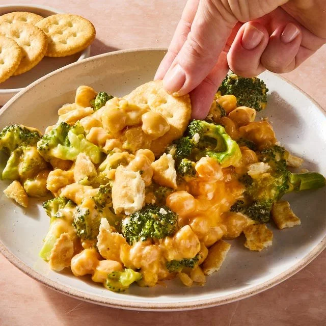 Cheesy broccoli cheddar chickpea skillet in a colorful frying pan