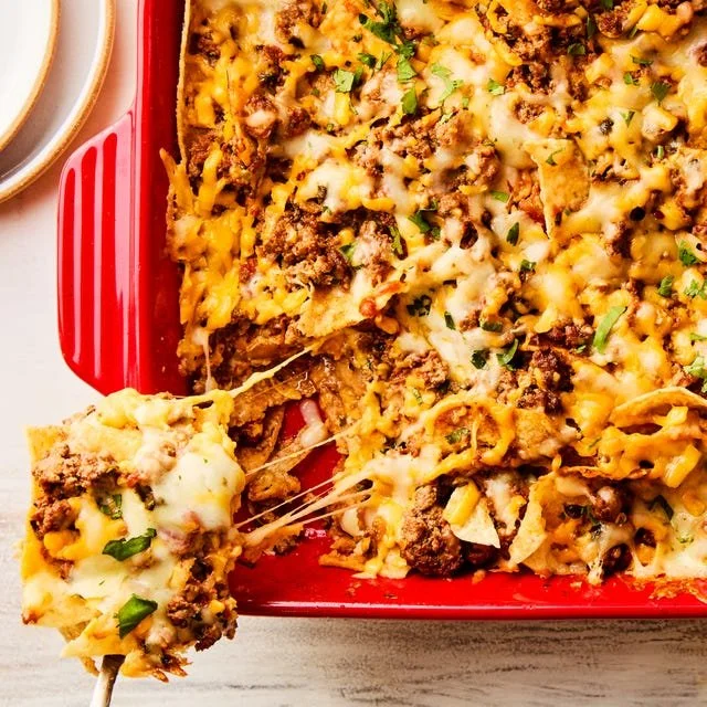 Delicious cheesy taco bake served in a glass dish with toppings