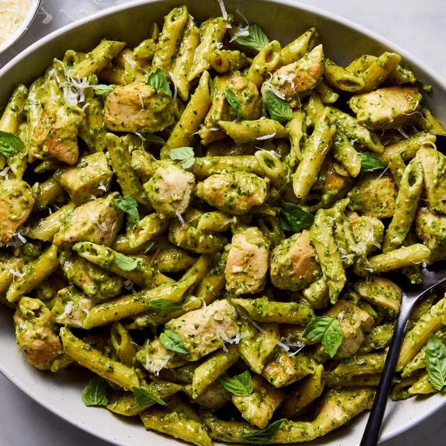 Delicious bowl of Chicken Pesto Pasta with fresh basil and grilled chicken