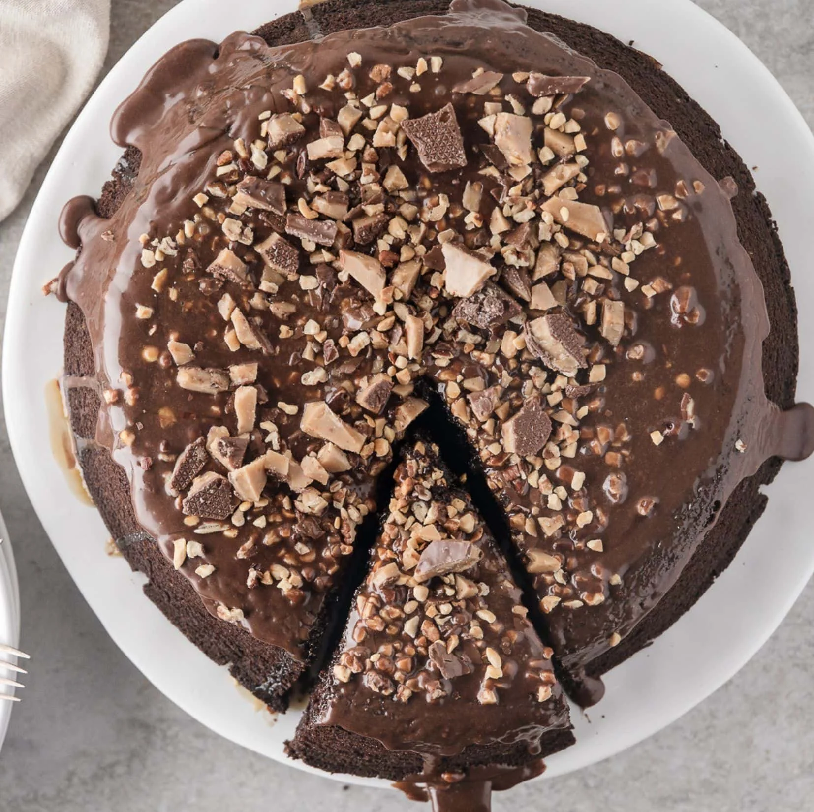 Decadent chocolate turtle cake topped with caramel and pecans