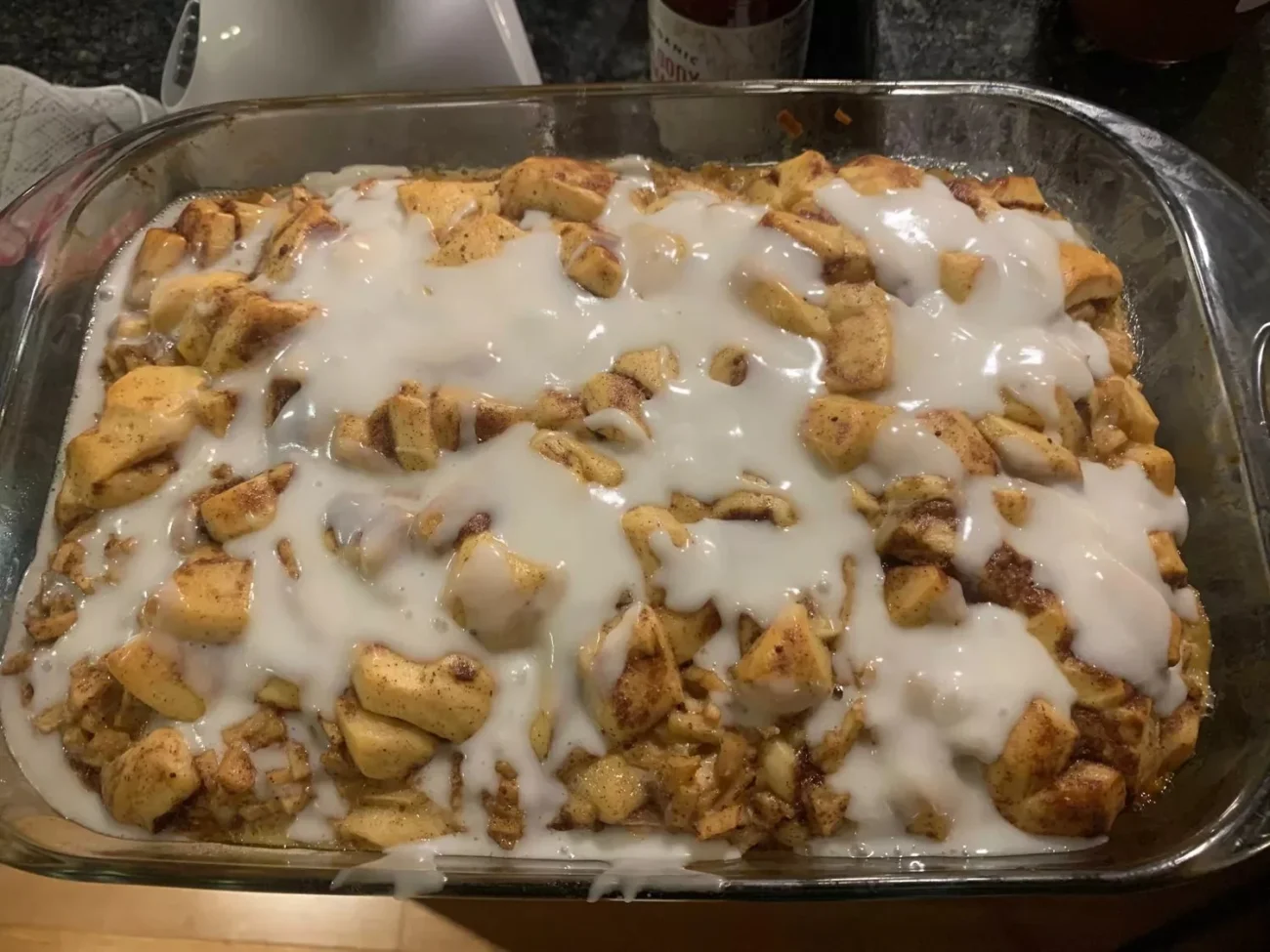 Cinnamon roll breakfast casserole topped with spiced apples and icing