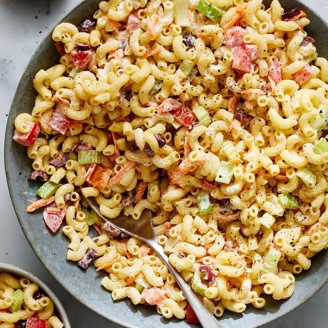 Bowl of classic macaroni salad with vegetables and creamy dressing