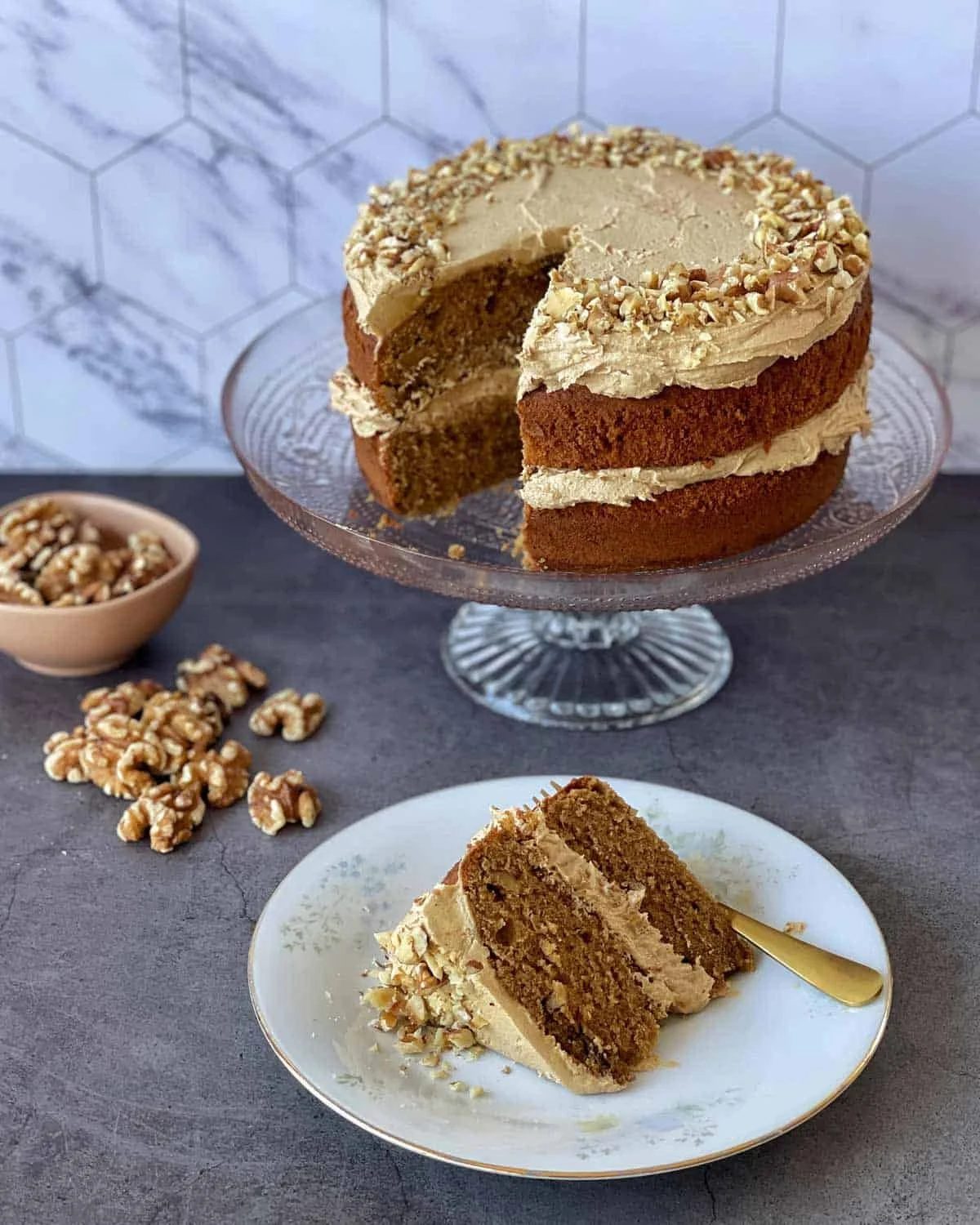 Slice of Coffee and Walnut Cake with coffee beans and walnuts on the side