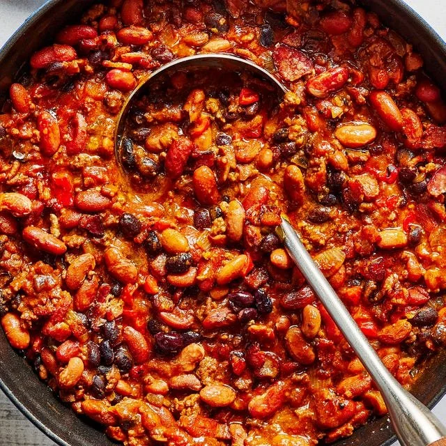 A bowl of delicious Cowboy Beans topped with fresh herbs and spices.