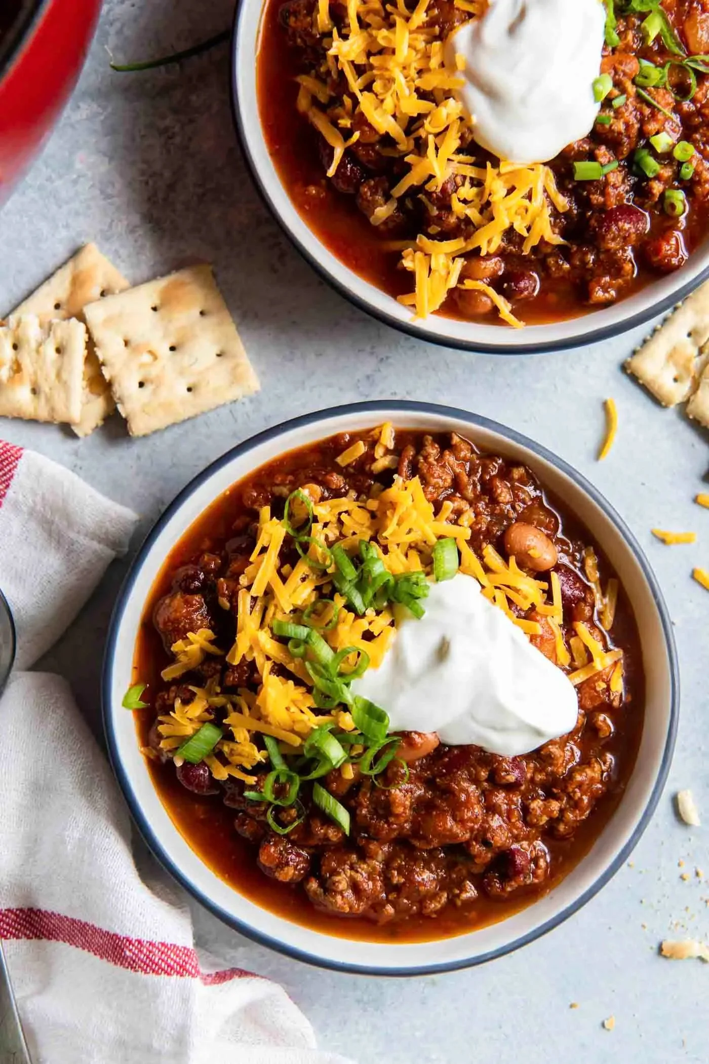 Bowl of cozy mouthwatering chili with toppings, perfect for a warm meal.