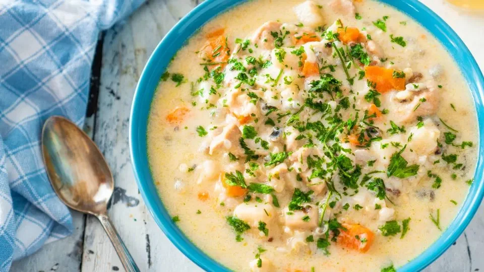 Creamy chicken and wild rice soup served in a bowl with fresh herbs