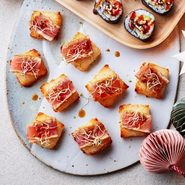 Crispy sushi rice cakes topped with seared tuna and garnished with herbs