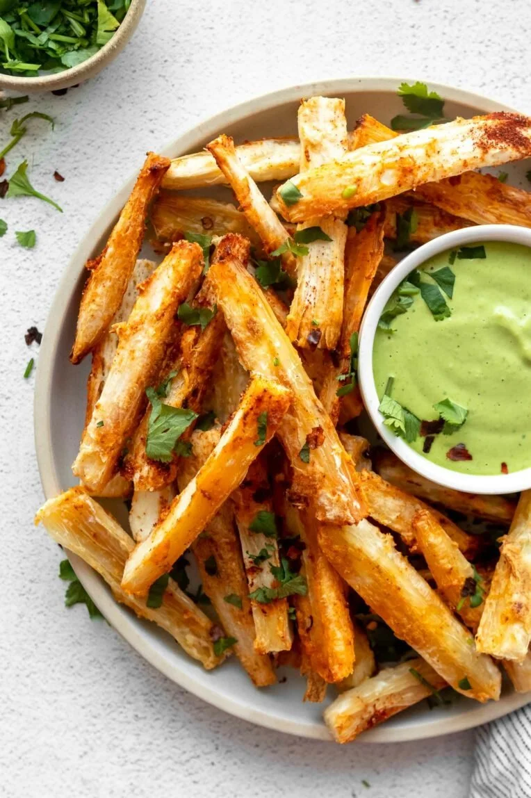 Crispy yuca fries with cilantro lime sauce served on a plate