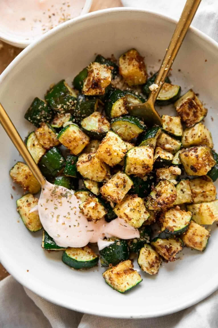 Plate of crispy zucchini bites garnished with herbs