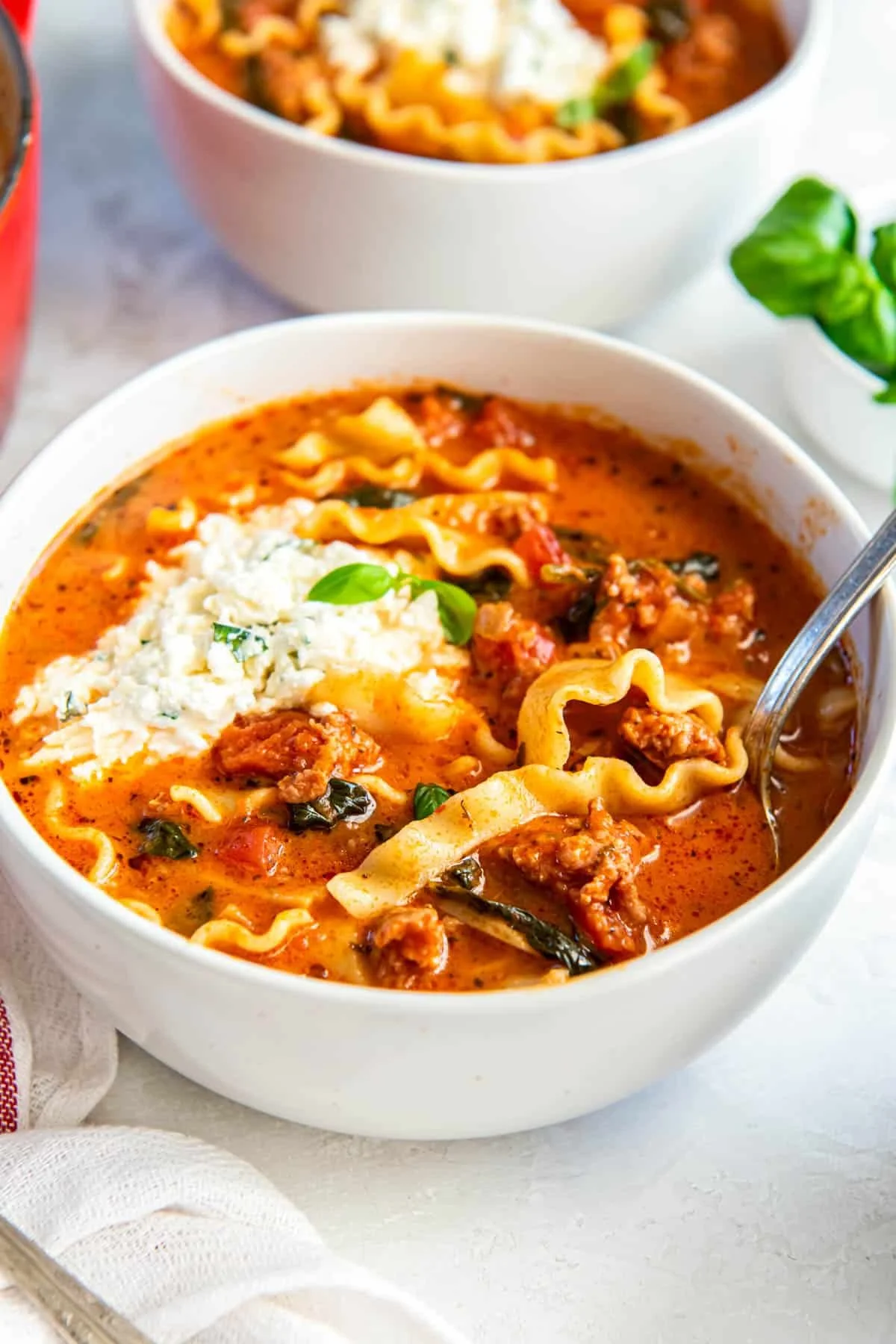 A bowl of delicious easy lasagna soup topped with melted cheese and herbs