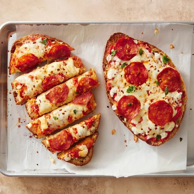 Homemade French Bread Pizza topped with cheese, pepperoni, and fresh herbs