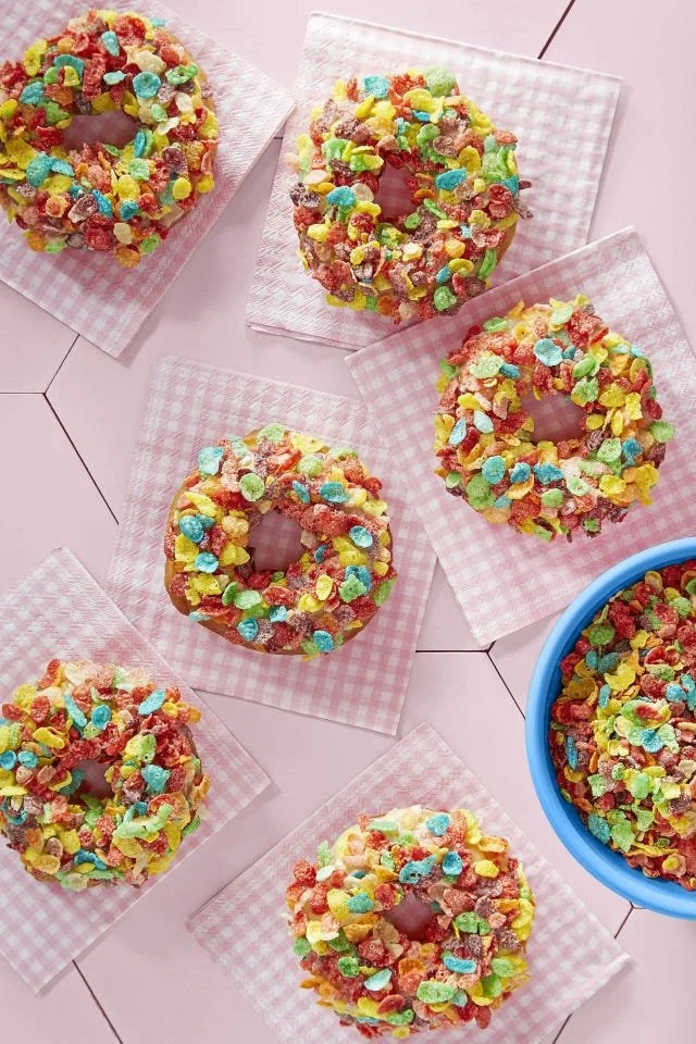 Colorful Fruity Pebbles Doughnuts topped with vibrant cereal sprinkles.