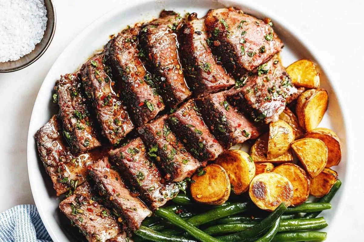 Garlic Herb Butter Steak prepared in the oven, garnished with fresh herbs.
