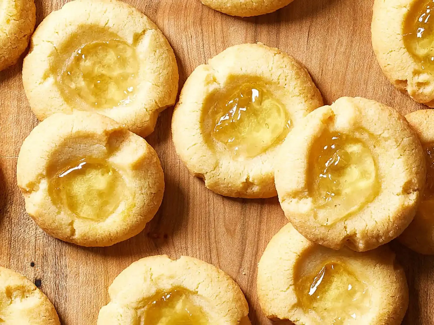 Jar of homemade apple jelly with fresh apples on a wooden table