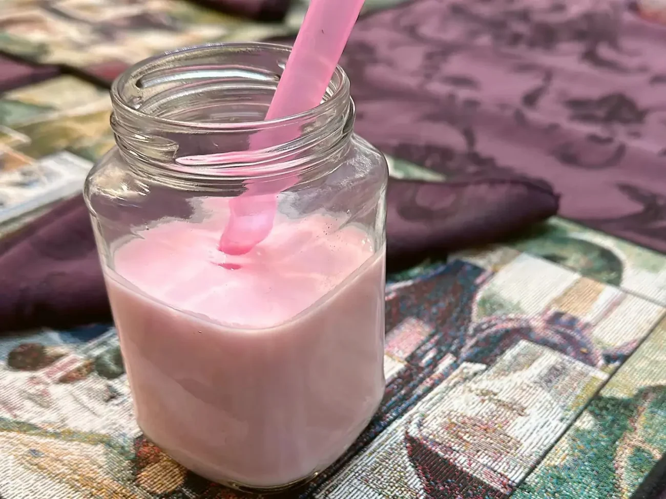 A refreshing glass of homemade strawberry kefir topped with fresh strawberries.