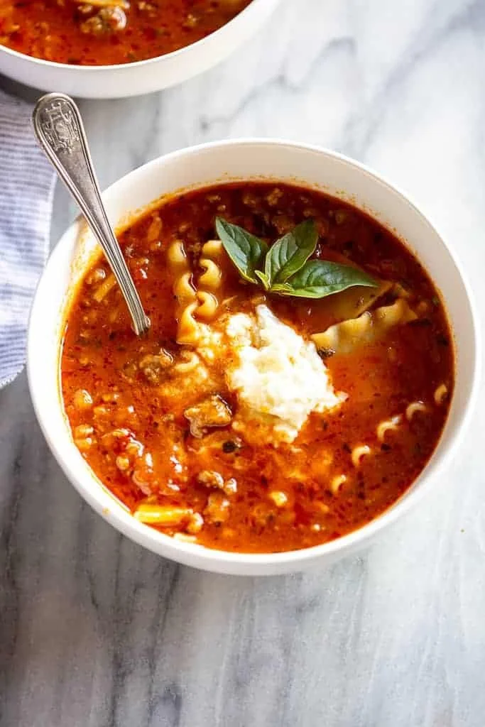 Bowl of delicious lasagna soup garnished with basil and cheese