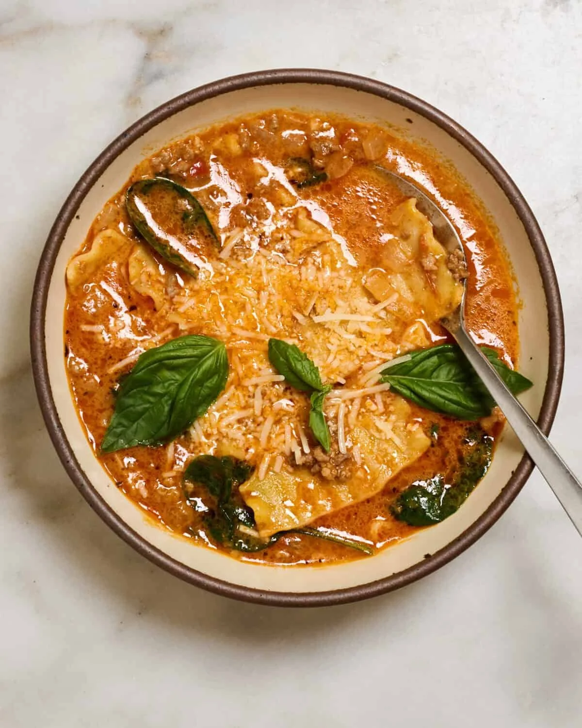 Bowl of hearty Lasagna Soup with cheese and herbs, a comforting meal.