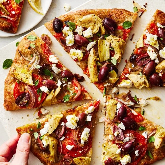 Delicious Mediterranean Pizza topped with olives, feta cheese, and fresh vegetables