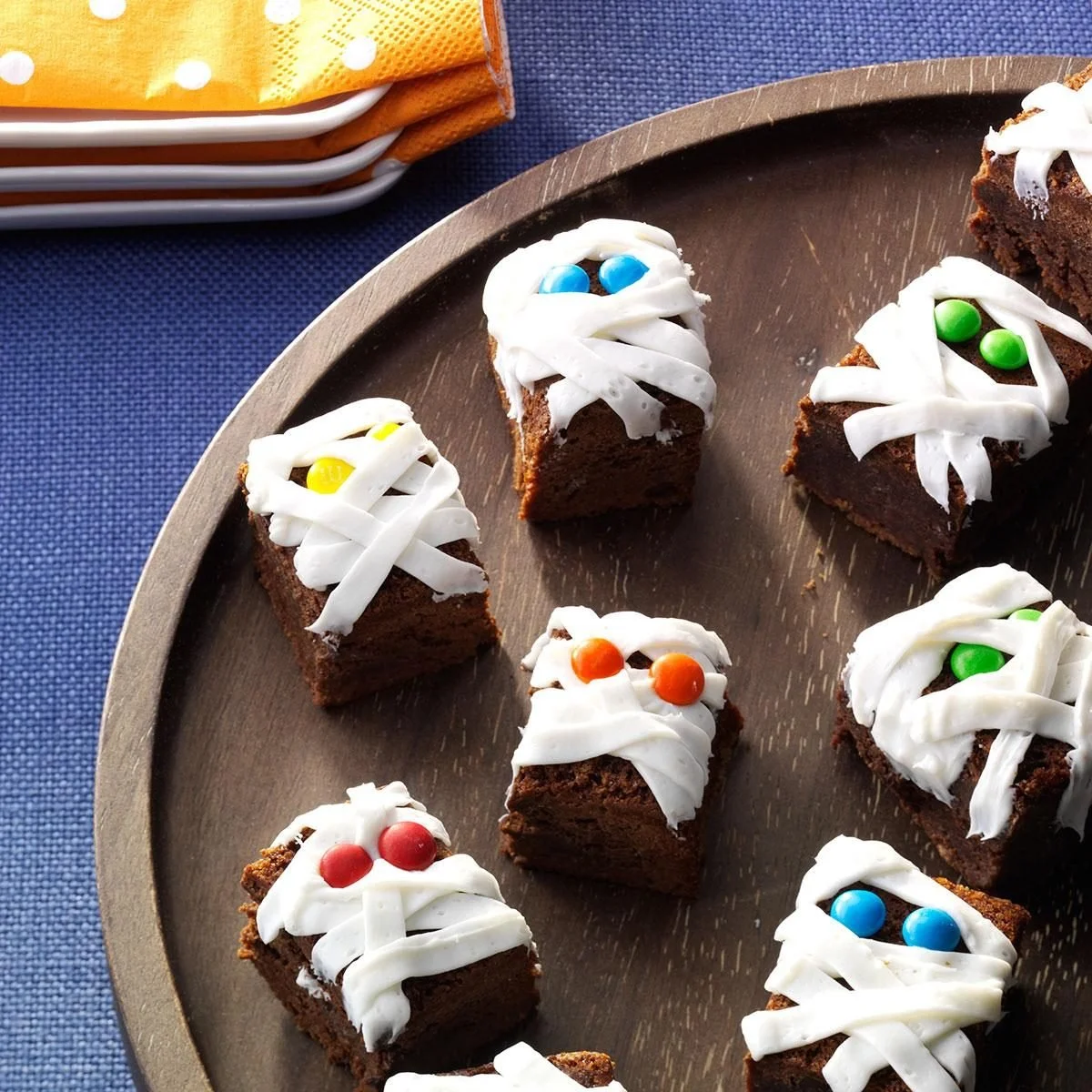 Halloween-themed Mummy Brownies decorated with white frosting and candy eyes