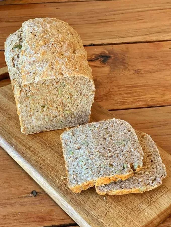 Freshly baked no-knead Birds Style Bread loaf on a wooden cutting board.