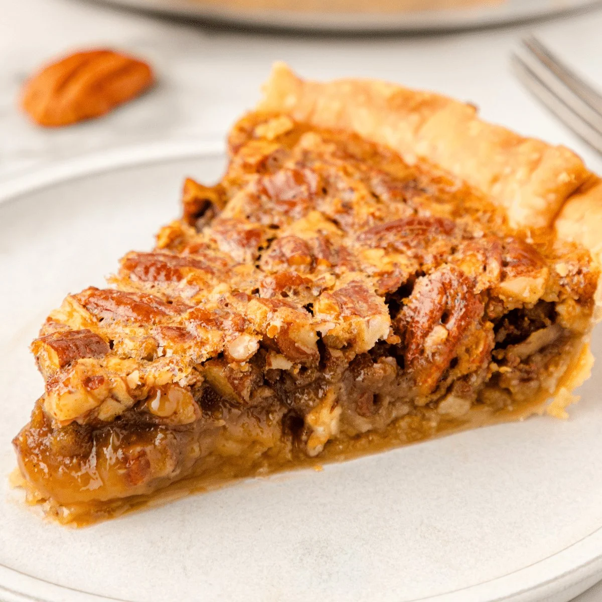 Delicious slice of homemade pecan pie with a golden crust and nutty filling.