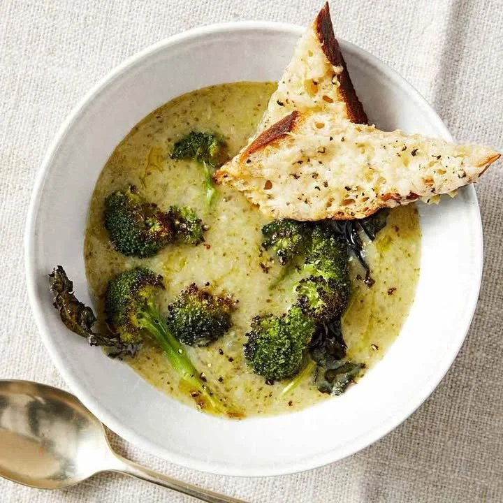 Creamy potato soup garnished with chives in a bowl on a wooden table