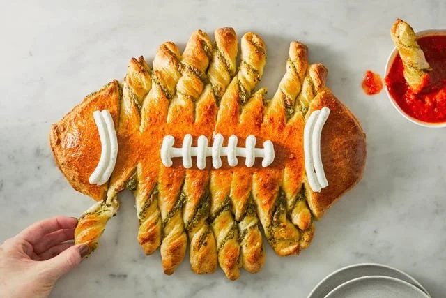 Delicious pull-apart Spinach-Artichoke Dip served in a football shape