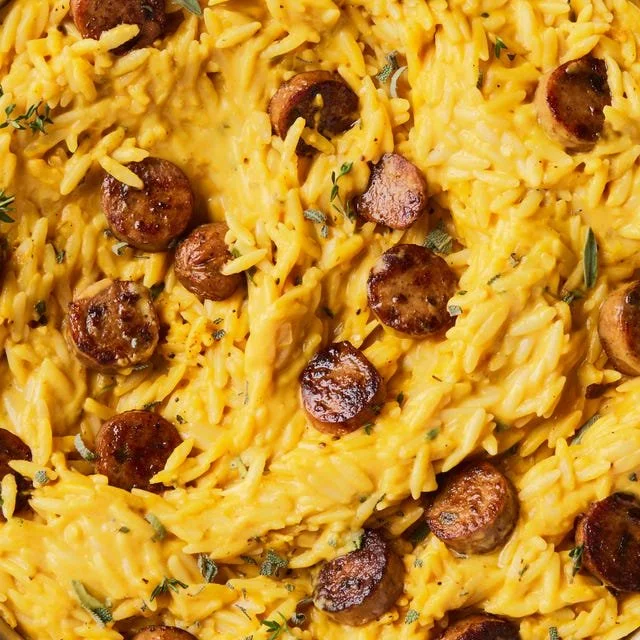 Creamy Pumpkin Orzo with Chicken Sausage garnished with fresh herbs