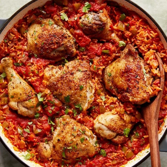 Plate of rice with chicken garnished with vegetables