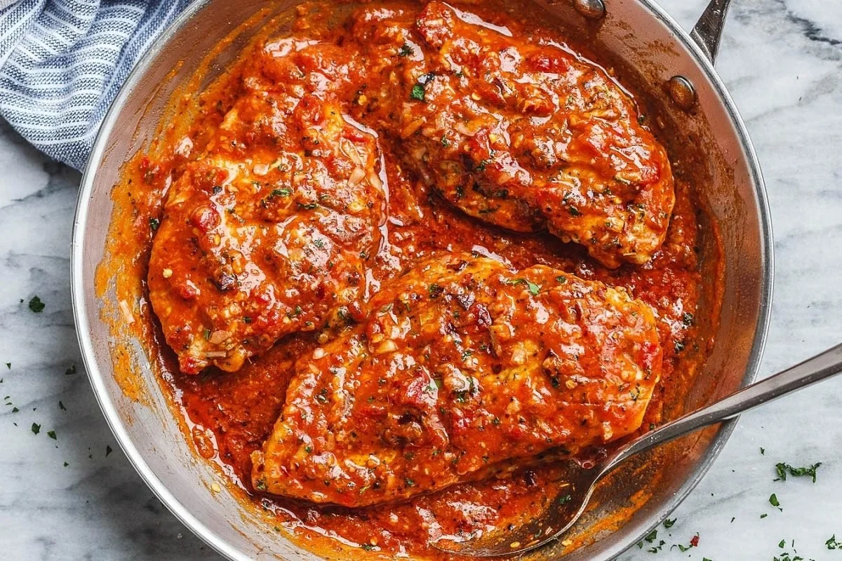 Skillet chicken in roasted pepper butter Parmesan sauce served on a plate