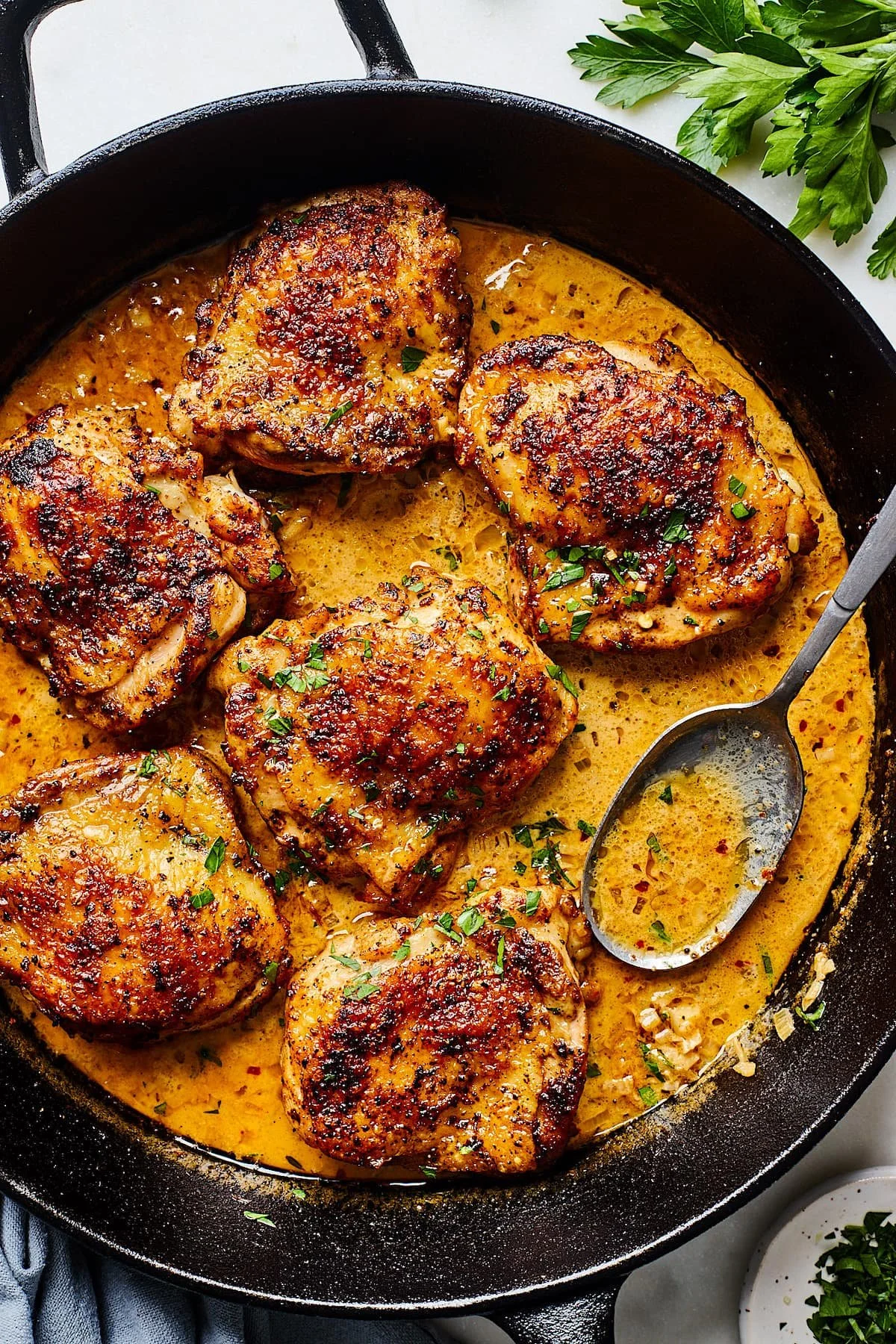 Skillet chicken thighs in creamy garlic sauce served in a skillet