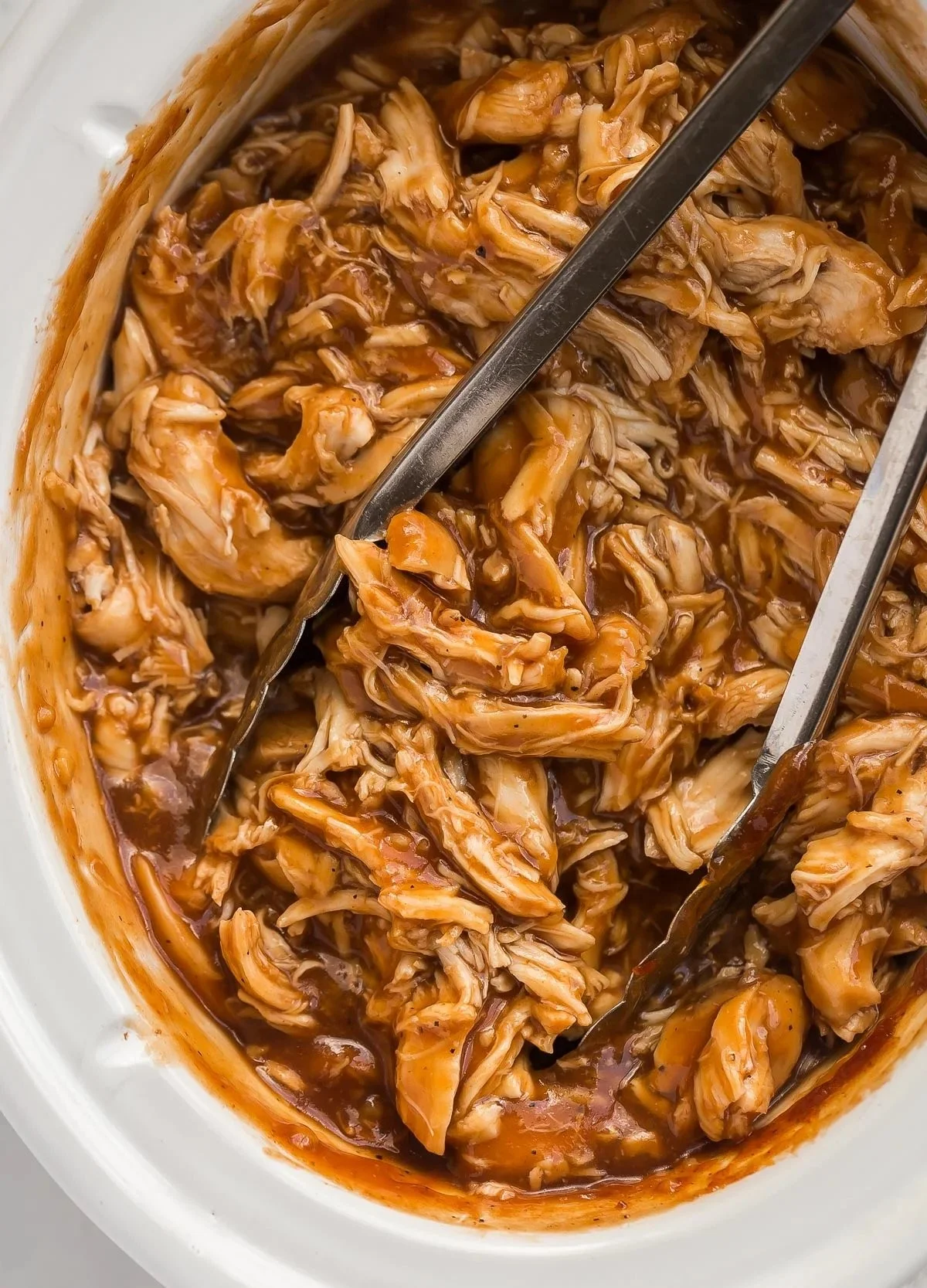 Slow cooker BBQ chicken dish served with sides on a rustic table