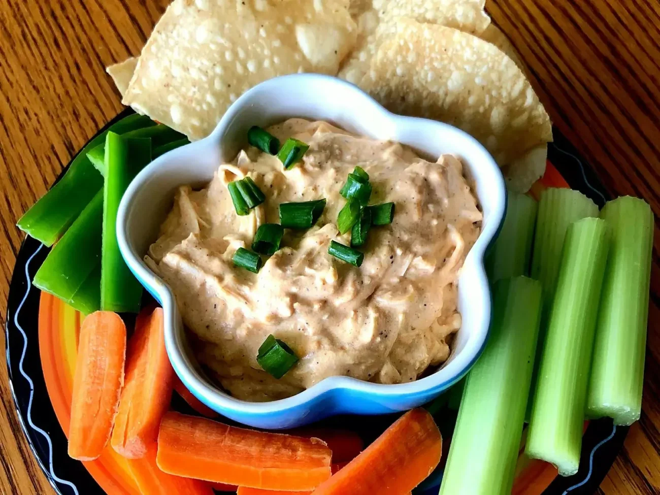 Slow Cooker Buffalo Chicken Dip in a bowl garnished with herbs