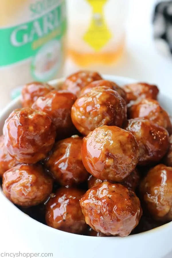 Slow cooker honey garlic meatballs served on a plate with a side of vegetables.