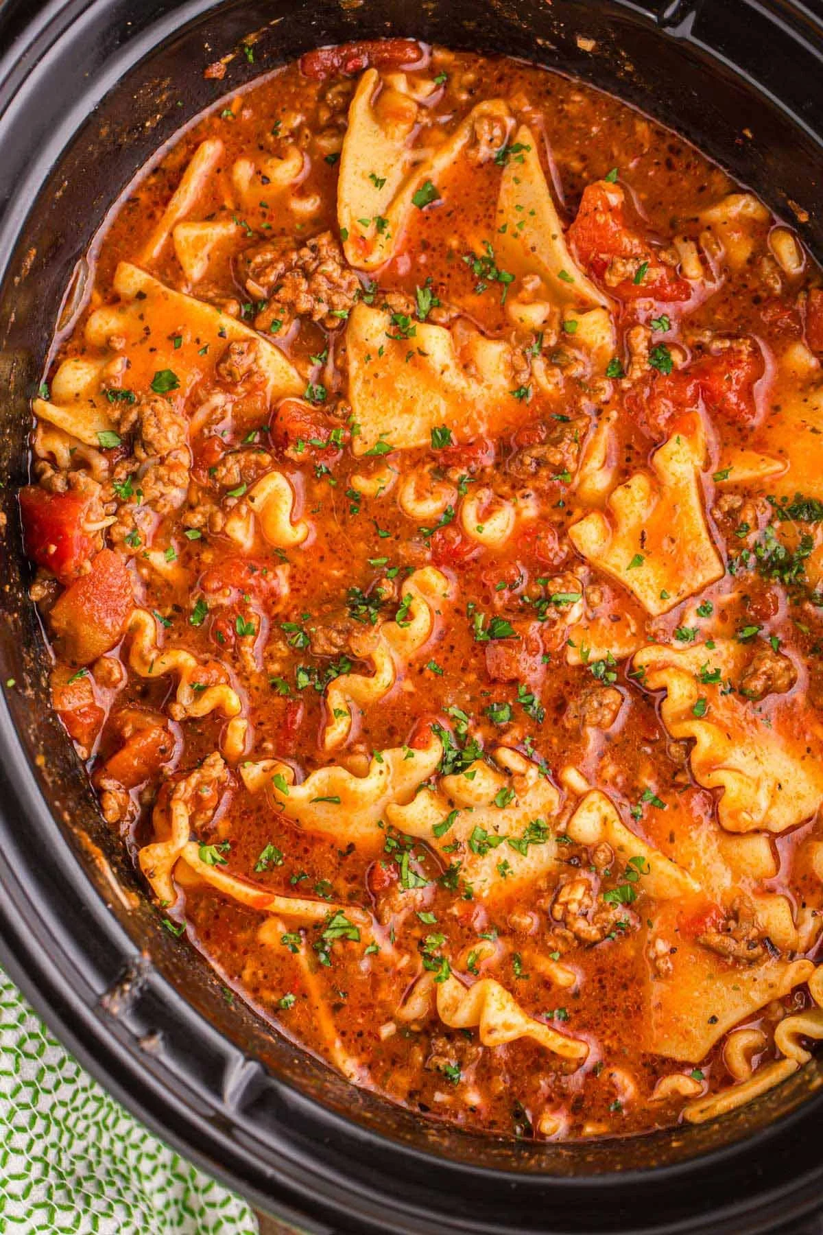 Delicious slow cooker lasagna soup served in a bowl with fresh herbs.