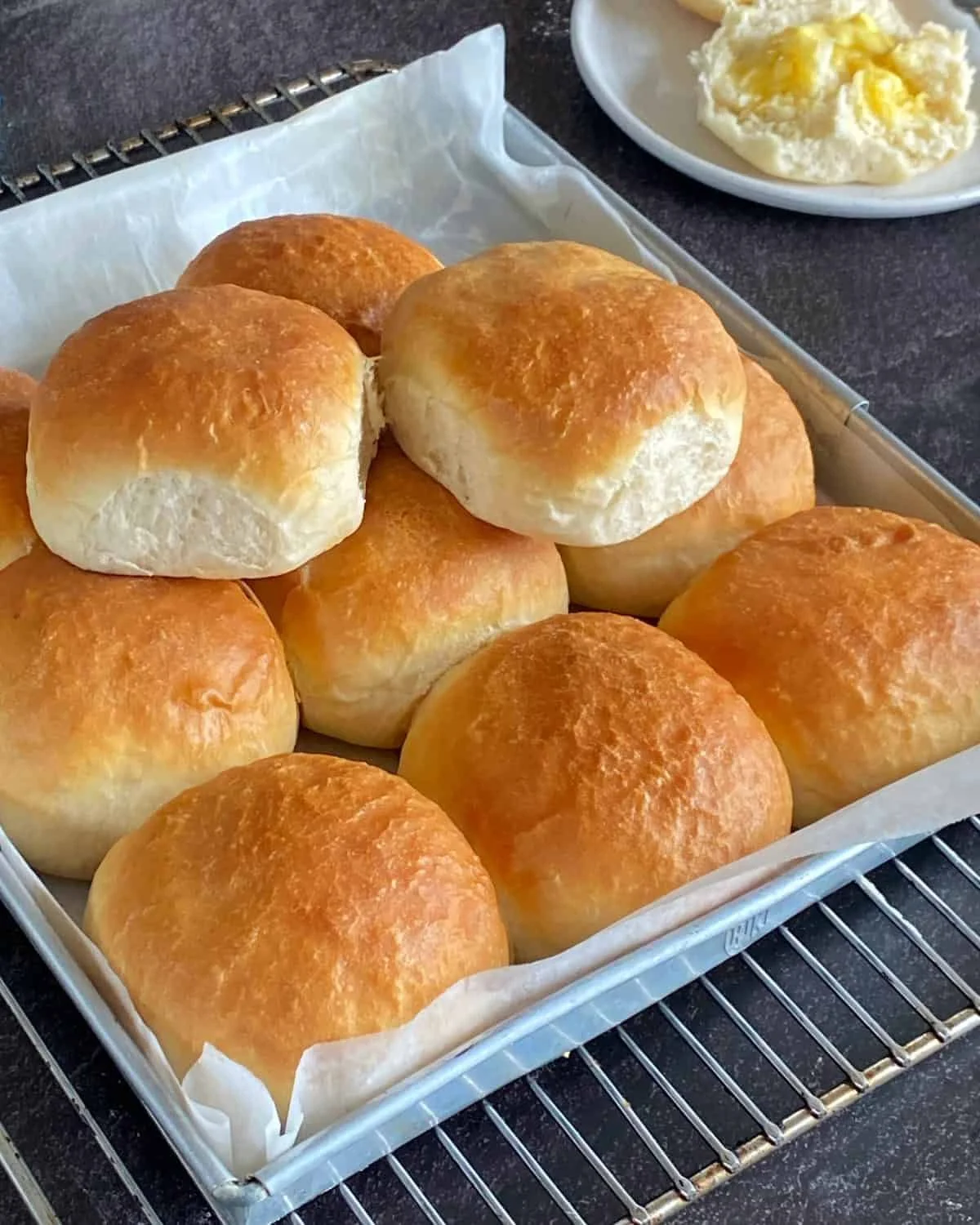 Freshly baked soft and fluffy dinner rolls on a wooden table