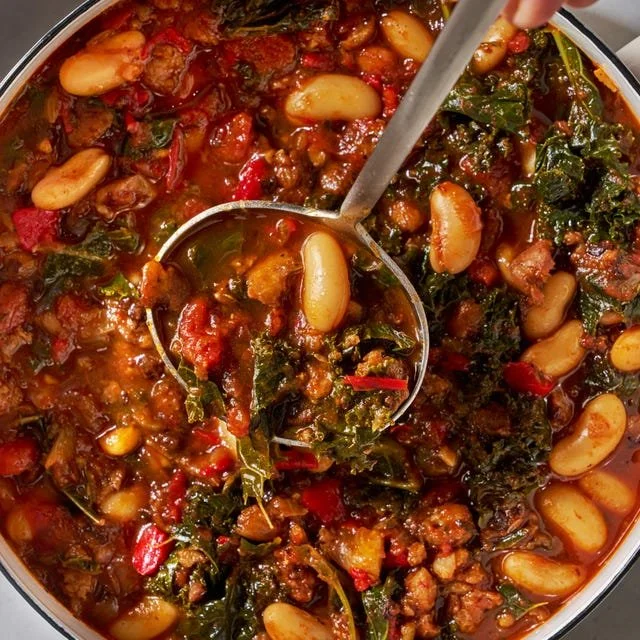 Bowl of Spicy Turkey Sausage and Kale Chili topped with herbs