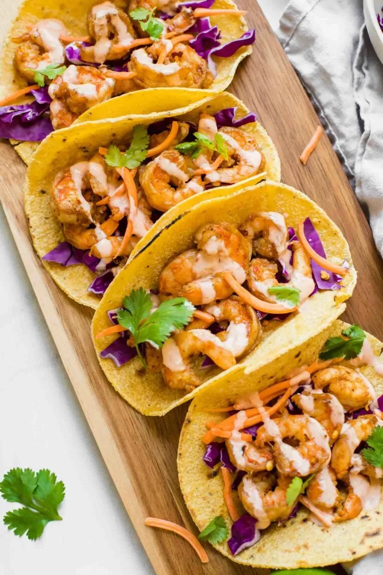 Sriracha Lime Shrimp Tacos served on a plate with fresh ingredients