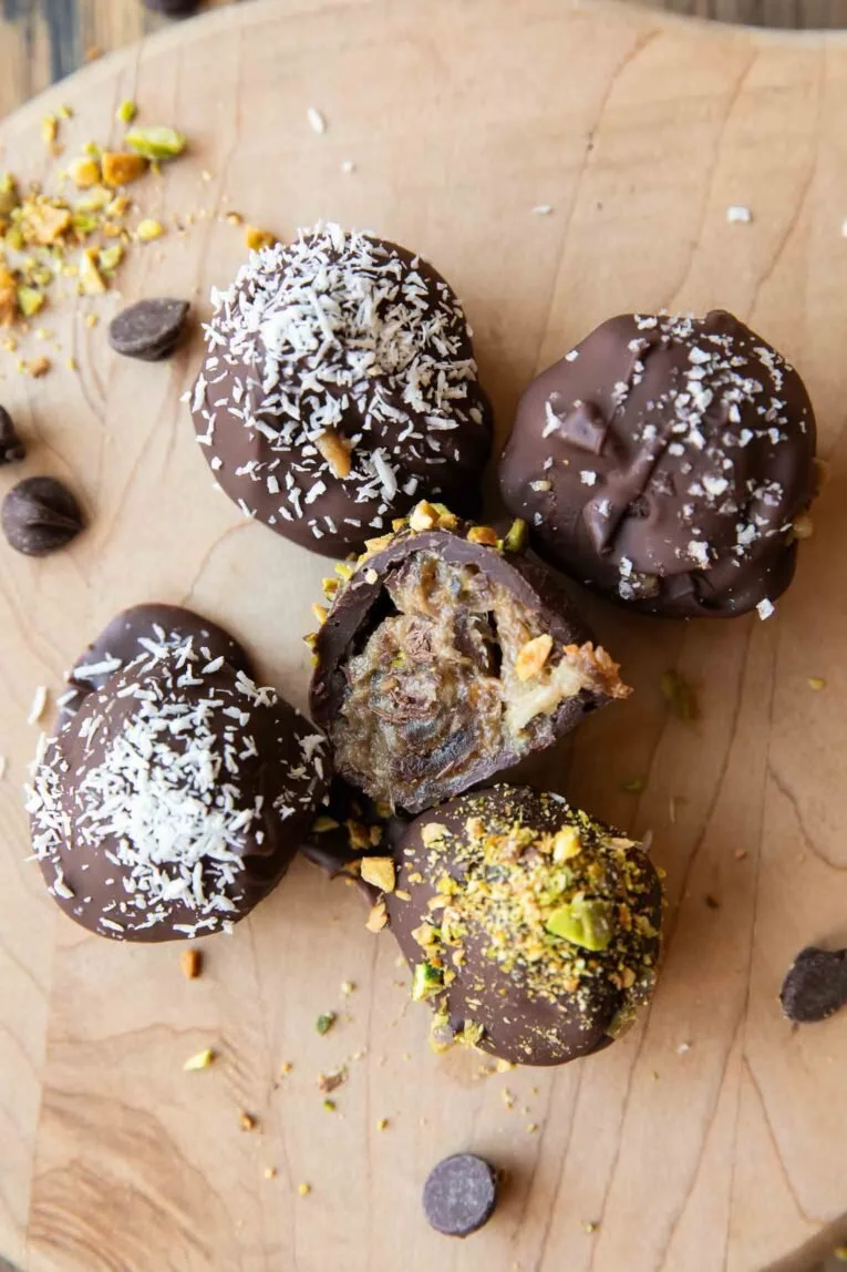Tahini salted caramel truffles topped with sea salt on a wooden surface