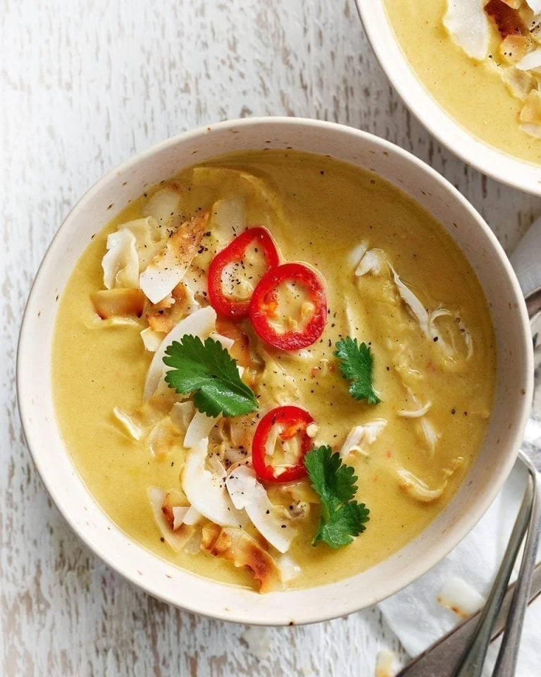 Bowl of fragrant Thai-spiced chicken soup with leeks and fresh herbs