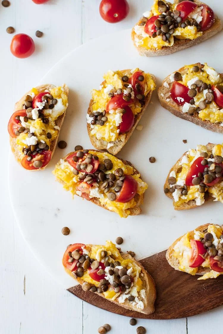 Delicious tomato & lentil breakfast bruschetta topped with fresh herbs