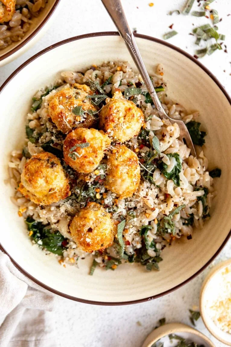 Delicious Turkey Sage Meatballs with cheesy orzo and kale on a plate