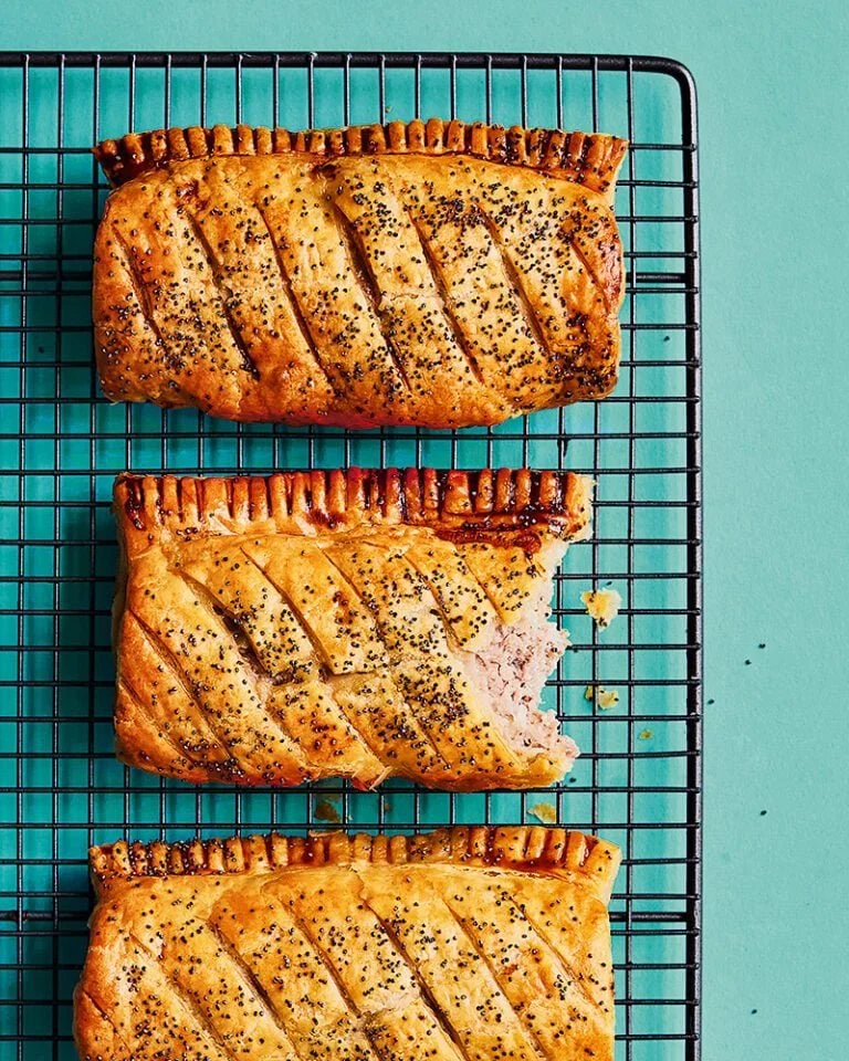 Freshly baked ultimate sausage rolls on a wooden board