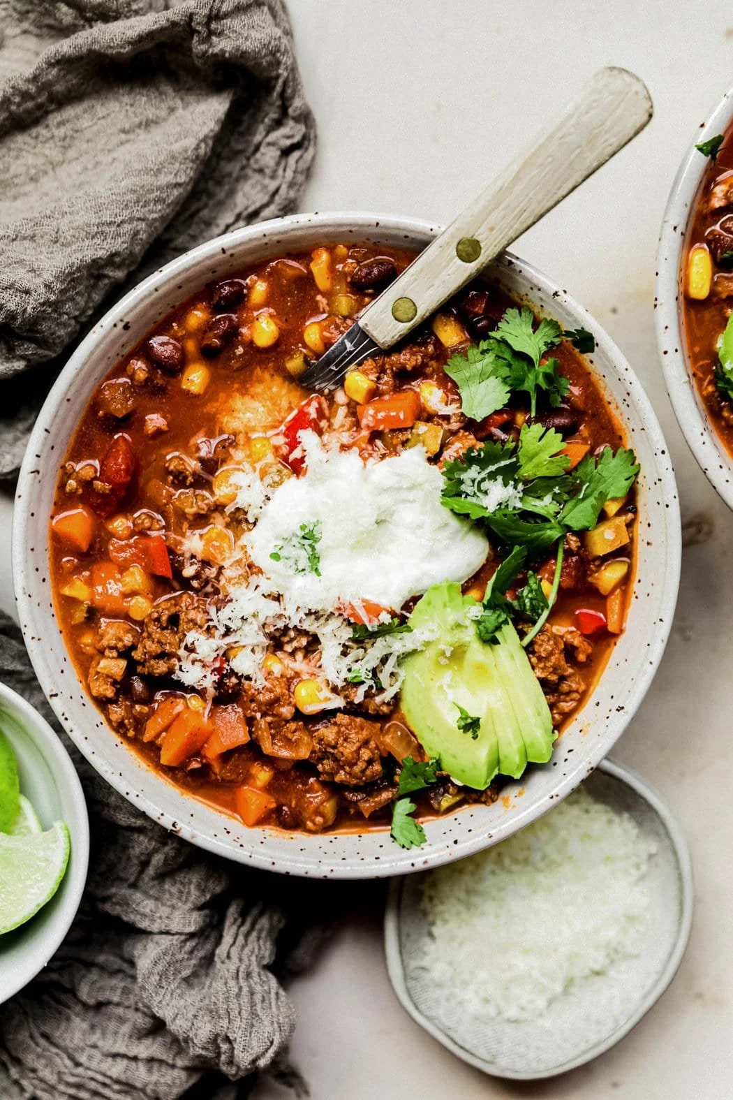 Bowl of veggie loaded turkey chili topped with fresh herbs and spices