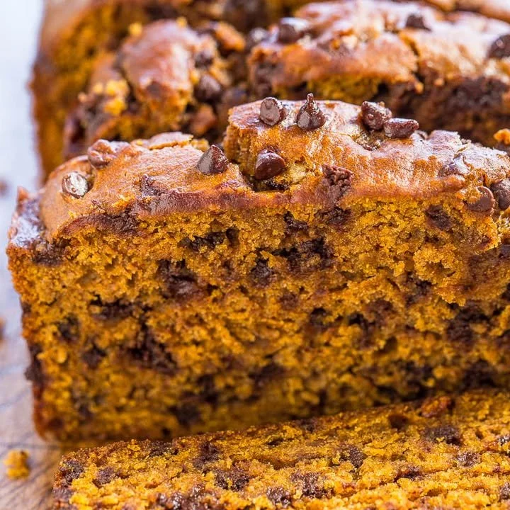 Homemade pumpkin chocolate chip bread sliced on a wooden board.