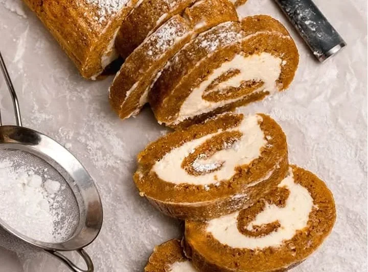 Delicious pumpkin roll dessert filled with cream cheese frosting and spices
